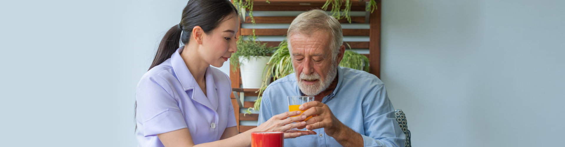 image of the ederly patient eating, asssisted by the home care staff